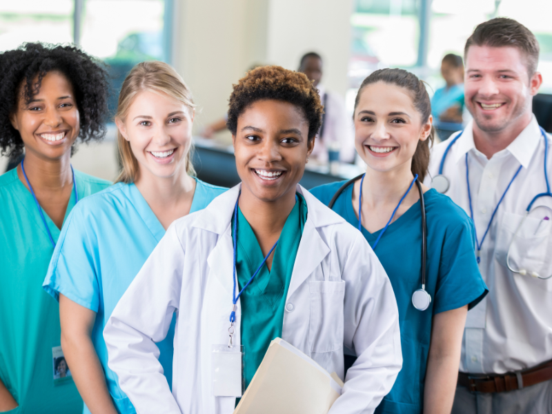 A team of five doctors standing next to each other.