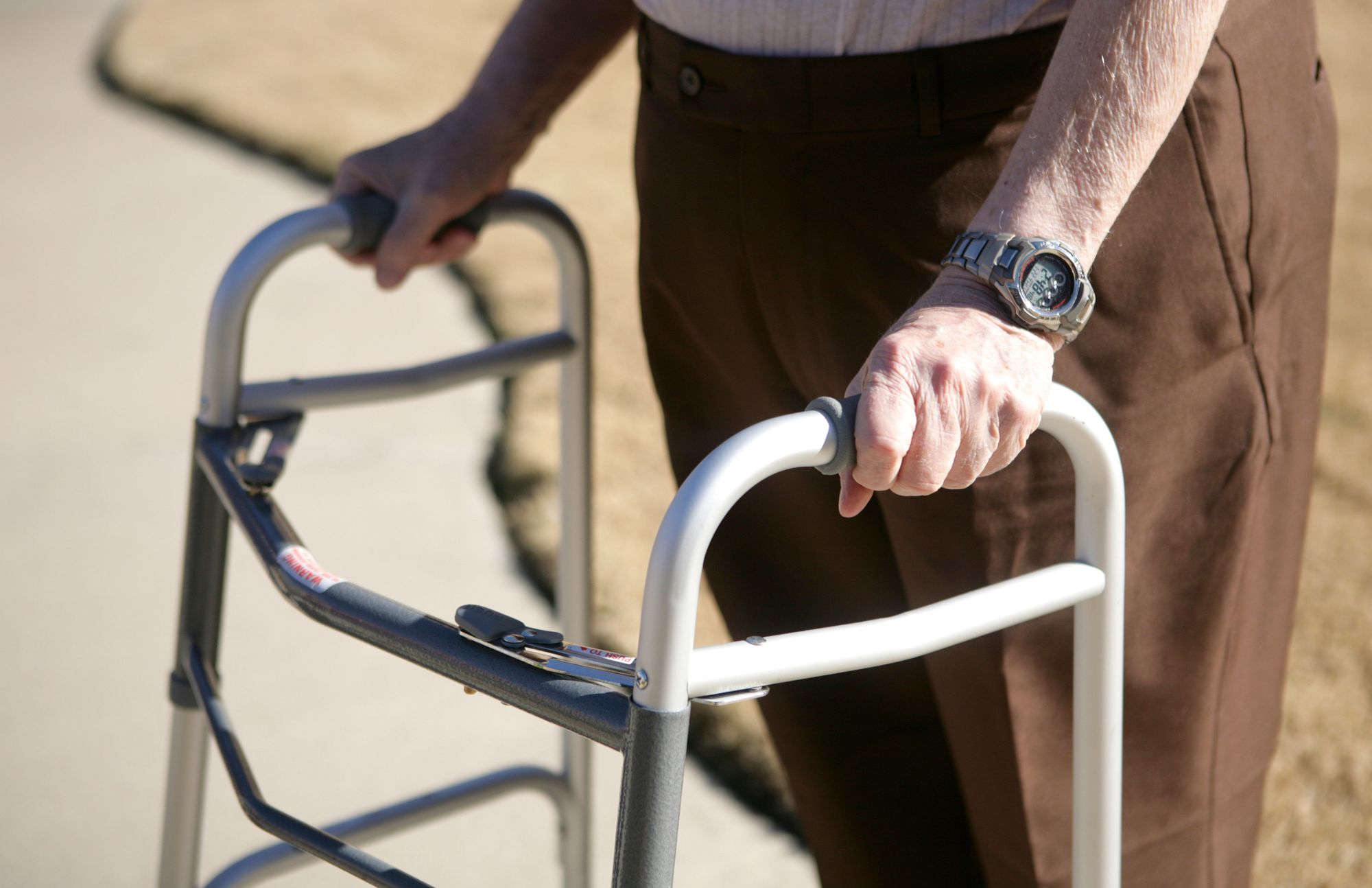 Man holding on to rolling walker.